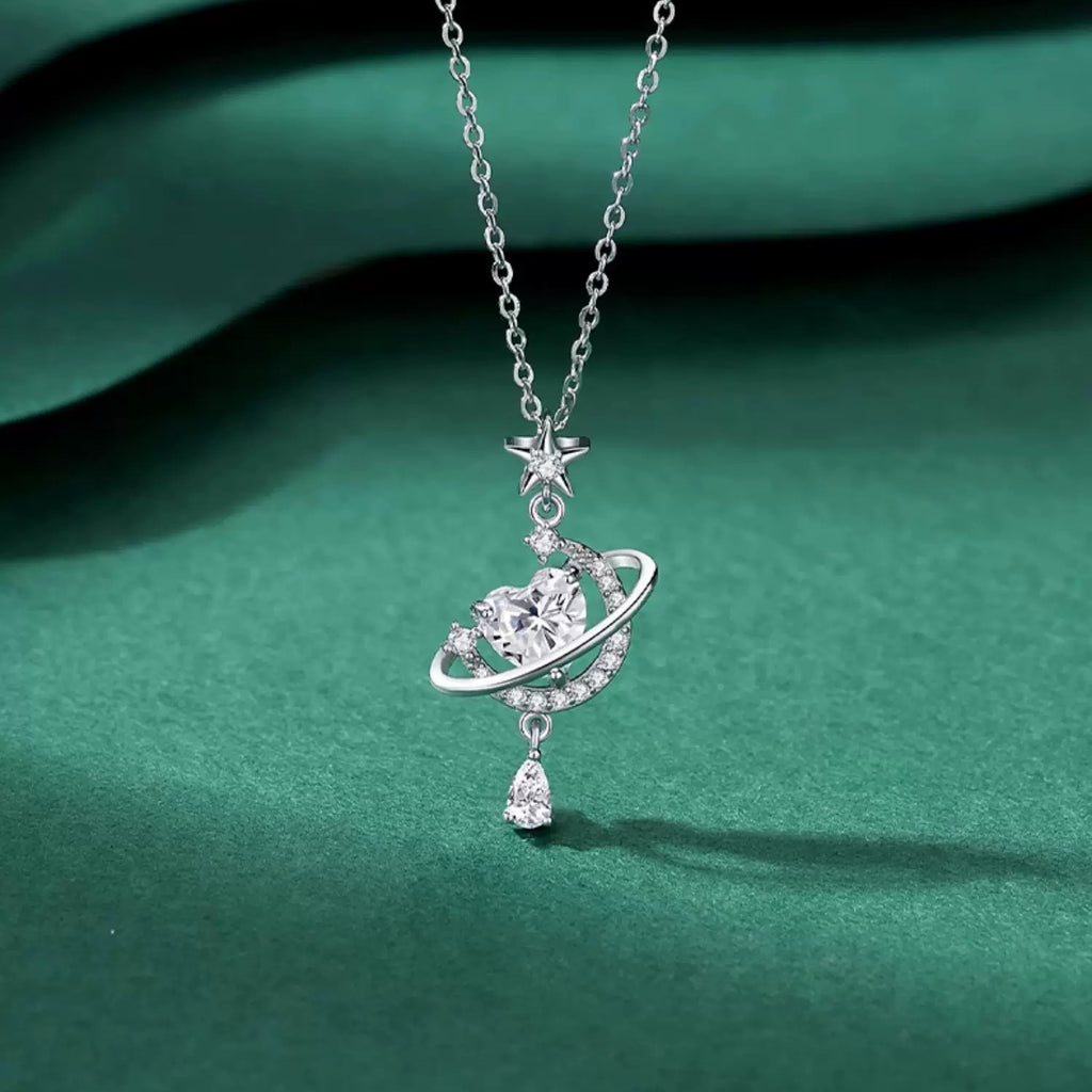 Sparkling Celestial Heart Planet Pendant Necklace on green background