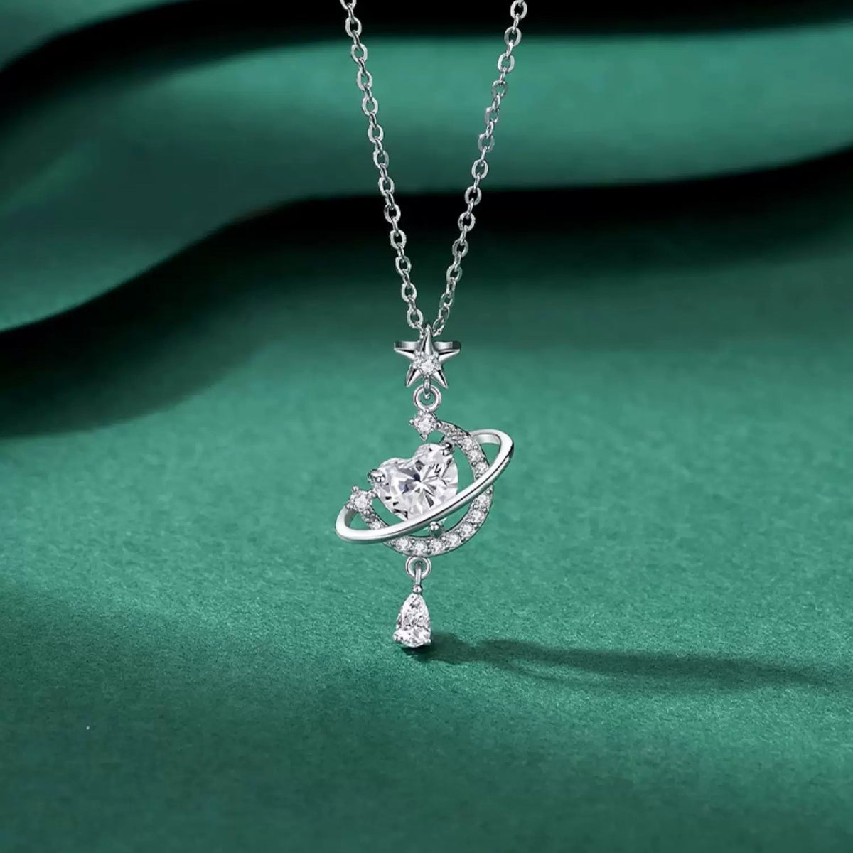 Sparkling Celestial Heart Planet Pendant Necklace on green background